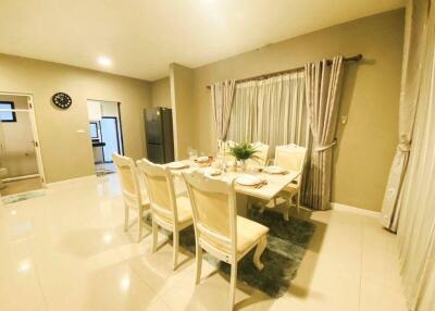 Spacious dining room with a set dining table, chairs, and elegant curtains