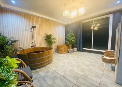 Modern bathroom with wooden bathtub and indoor plants