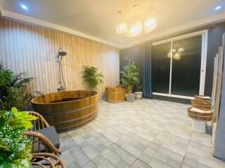 Modern bathroom with wooden bathtub and indoor plants