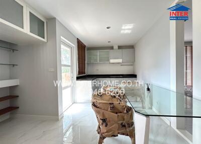 Modern minimalist kitchen with large window, dining area, and glass table