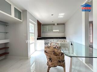 Modern minimalist kitchen with large window, dining area, and glass table