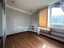 Empty bedroom with wooden floors and large window