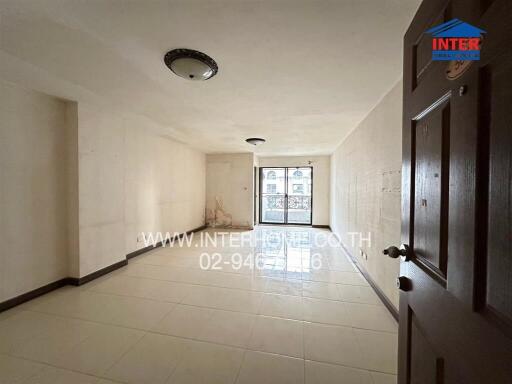 Spacious vacant living room with ceiling lights and tiled flooring