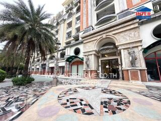 Front view of an elegant building with intricate design and palm trees