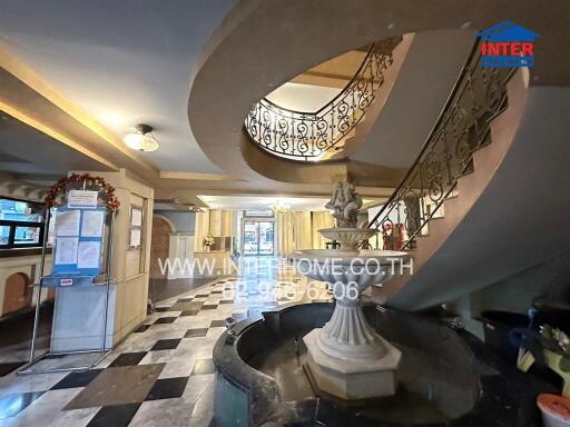 Lobby with a decorative water fountain and spiral staircase