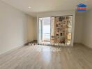 Empty bedroom with balcony access and light wood flooring