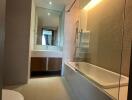 Modern bathroom with bathtub, mirrored vanity, and recessed lighting