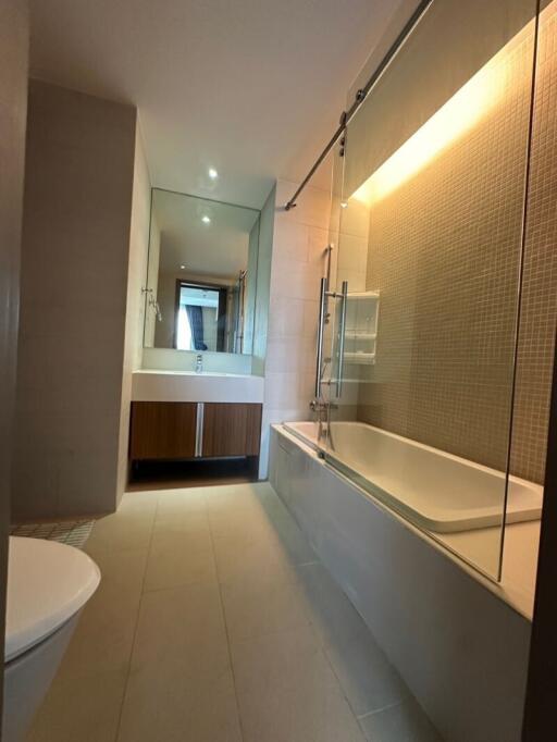 Modern bathroom with bathtub, mirrored vanity, and recessed lighting