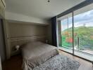 A cozy bedroom with a large window overlooking a scenic view