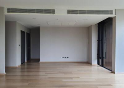 Spacious empty room with wooden flooring and large windows