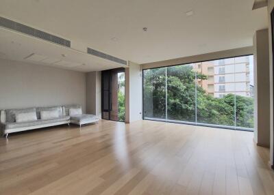 Spacious living room with floor-to-ceiling windows and a view of greenery