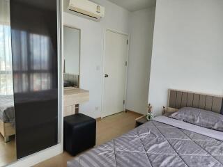 Modern bedroom with bed, air conditioner, and dressing table