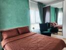 Bedroom with green walls, a brown bedspread, and a mirrored wardrobe