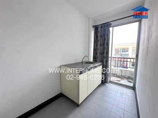 Small minimalist kitchen with sink, counter, and large window with balcony view