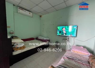 Small bedroom with two beds, air conditioning, and a wall-mounted television