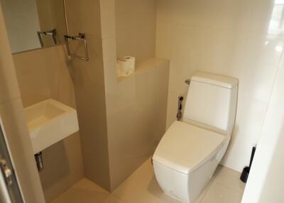 Compact modern bathroom with toilet and small sink
