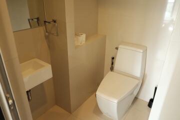 Compact modern bathroom with toilet and small sink