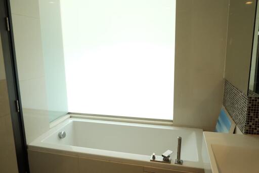 Modern bathroom with bathtub and frosted window