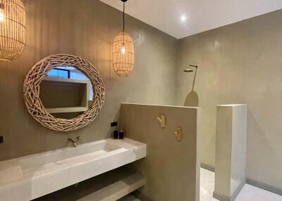 Modern bathroom with minimalist design featuring a large vanity mirror and pendant lights