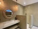 Modern bathroom with minimalist design featuring a large vanity mirror and pendant lights