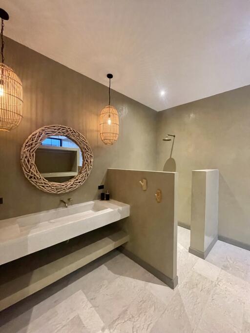 Modern bathroom with minimalist design featuring a large vanity mirror and pendant lights