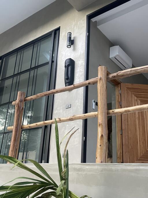 Entryway of a modern building with a wooden handrail and potted plants