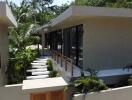 Modern exterior view of property with walkway and lush greenery