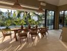 Spacious dining area with wooden furniture and large windows overlooking a pool