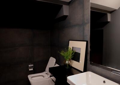 Modern bathroom with dark tiles and stylish fixtures