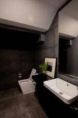 Modern bathroom with dark tiles and stylish fixtures