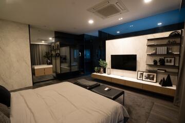 Modern bedroom with wall-mounted TV and shelves