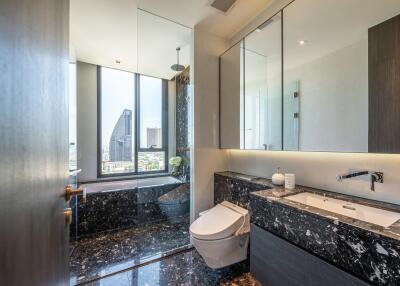 Modern bathroom with marble flooring, glass shower, and city view