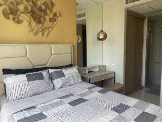 Modern bedroom with decorative wall art, bed, and attached en-suite bathroom