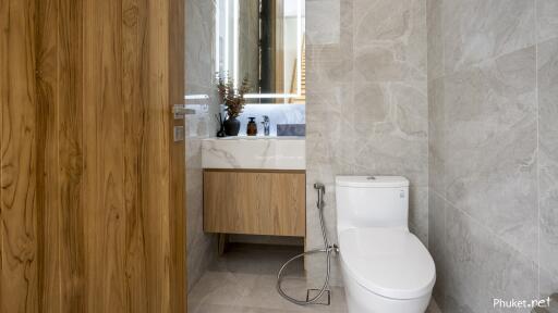 Modern bathroom with wooden door and marble tiles