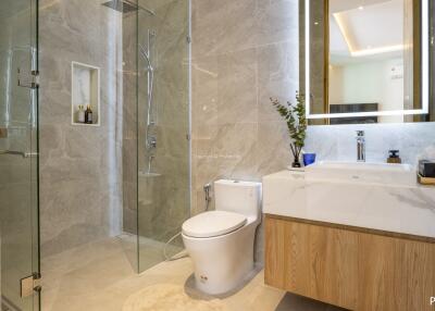 Modern bathroom with glass-enclosed shower, toilet, and sink with a mirror