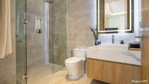 Modern bathroom with glass-enclosed shower, toilet, and sink with a mirror