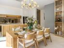 Modern dining room with wooden table and chairs, adjacent to open kitchen