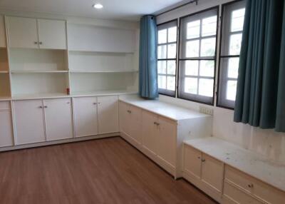 Spacious living room with large windows and built-in cabinetry