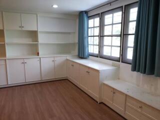 Spacious living room with large windows and built-in cabinetry