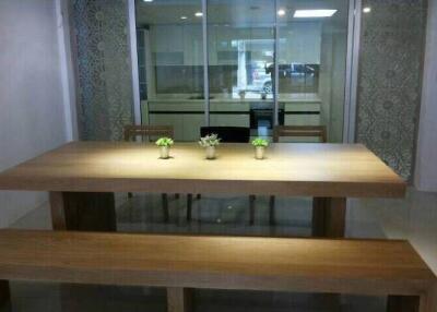 Spacious dining area with wooden table and benches, featuring decorative glass panels