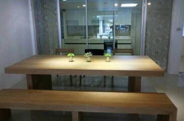 Spacious dining area with wooden table and benches, featuring decorative glass panels