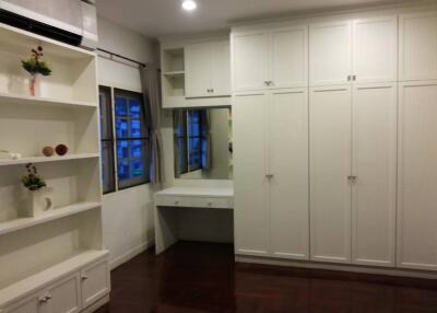 Spacious bedroom with built-in closets, vanity table, and shelving