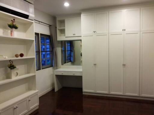 Spacious bedroom with built-in closets, vanity table, and shelving