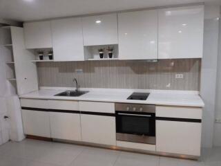 Modern white kitchen with cabinetry and appliances