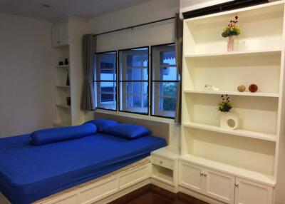 Bedroom with large window and built-in shelves