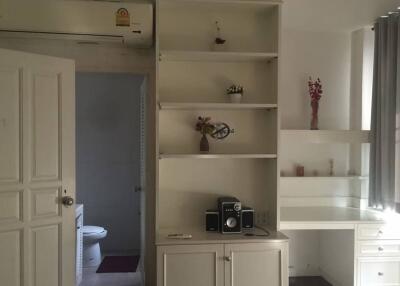 An interior view with shelves, a desk, and a partially visible bathroom