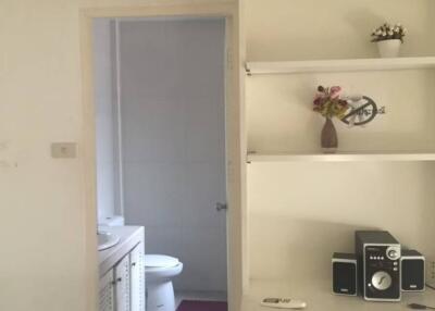 hallway leading to bathroom with small cabinets and air conditioning unit