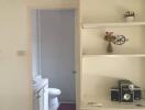 hallway leading to bathroom with small cabinets and air conditioning unit