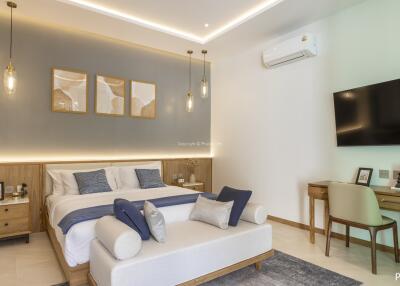 Modern bedroom with a king-sized bed, decorative lights, air conditioning, and a wall-mounted TV
