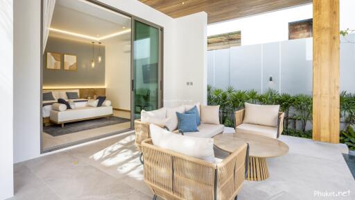 A cozy outdoor seating area connected to an interior view of a modern living room